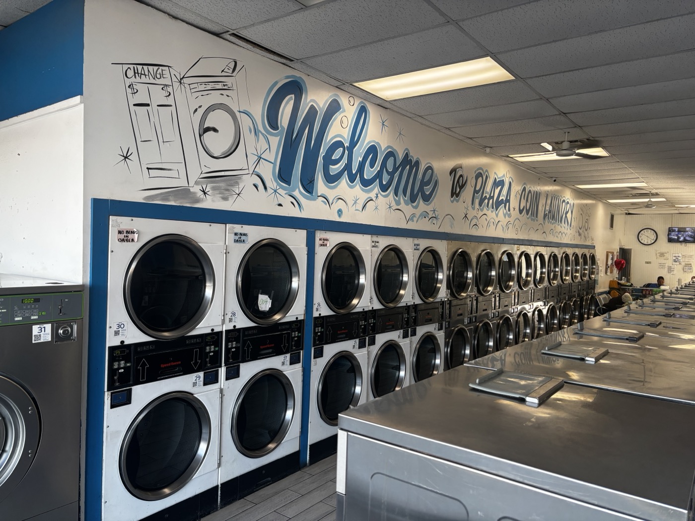Dryers and folding area at Plaza Coin Laundry