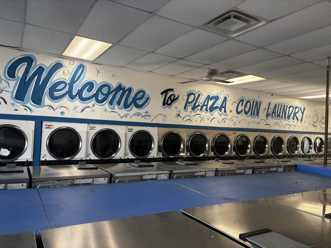 Welcome to Plaza Coin Laundry interior mural with dryers