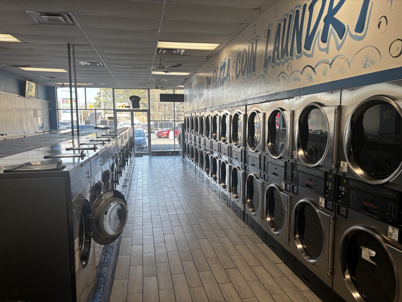 Rows of washers and dryers inside Plaza Coin Laundry